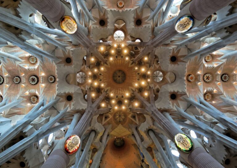 Vista interior de la Sagrada Familia en Barcelona, destacando sus imponentes columnas que imitan la forma de un bosque y la luz natural que entra por las vidrieras.