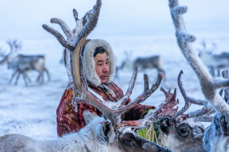 Mujer indígena Nénets vistiendo la ropa tradicional de invierno en el paisaje nevado de Siberia.
